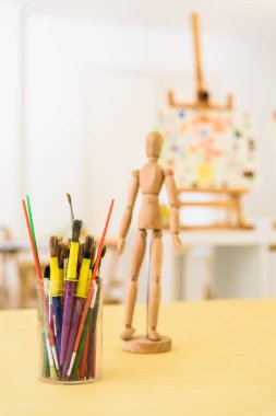 Ahşap renkli boya fırçaları ve insan modelleme bebek.