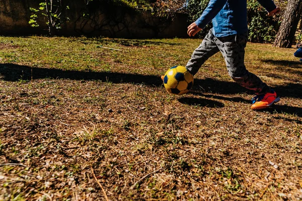 Kinder jagen einem alten Fußball in einem Freundschaftsspiel in Summa nach — Stockfoto