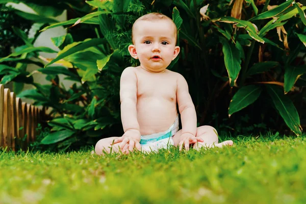 Bayi dengan popok duduk di rumput . — Stok Foto