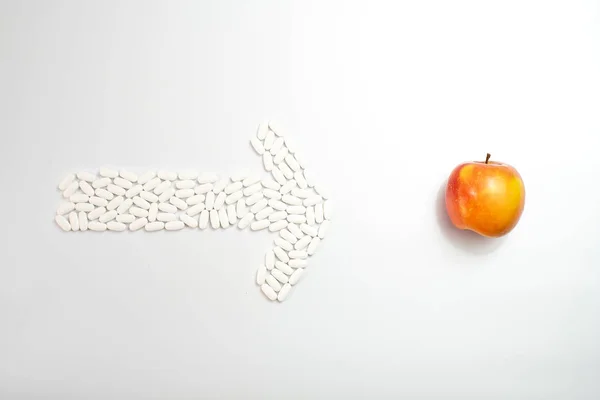 Flecha con pastillas que apuntan a una fruta contra suplementos, concepto o — Foto de Stock