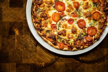 Ev yapımı pizza koyu ahşap sekmesinde hızlı ve sağlıklı gıda olarak pişmiş