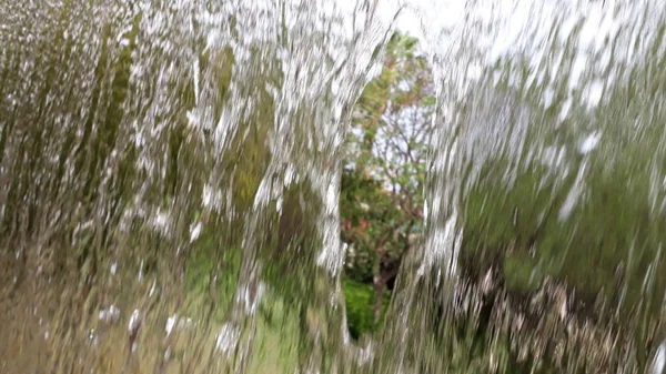 Amplia corriente de agua que cae en un parque semi-translúcido — Foto de Stock