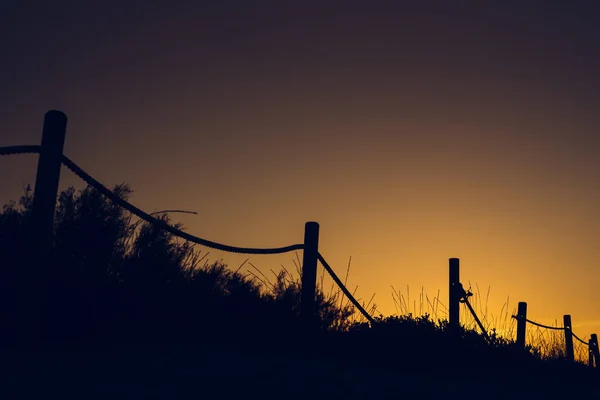 Varm solnedgång med silhuetten av stranden dunes — Stockfoto