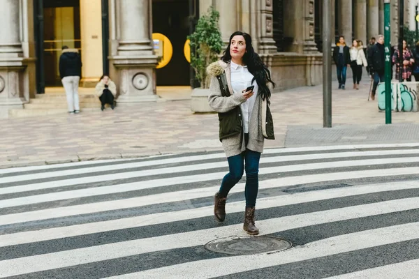 Tourist woman crossing a lost street while consulting a map on h — Stock Photo, Image