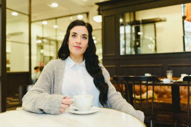 Sıcak bir kahve olan bir kafede ev kadını.