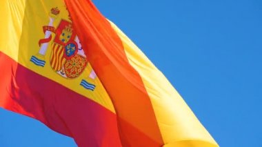 Ulusal İspanyol bayrağı güneşli bir günde rüzgarda dalgalanıyor.