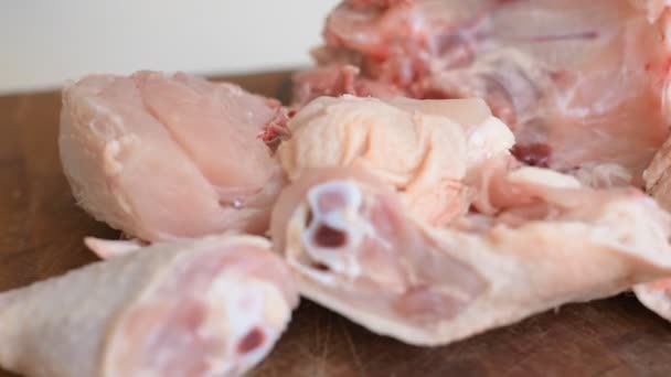 木製の板に鶏のドラムスティックを切る肉屋のクローズアップ — ストック動画