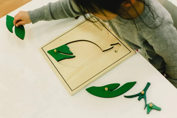 Small pupils in a nursery school handling educational puzzles.