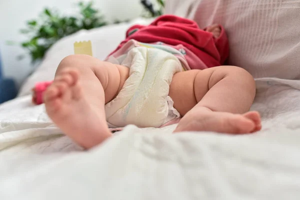 Newborn baby laying on a sofa with disposable diapers ready to c — Stock Photo, Image