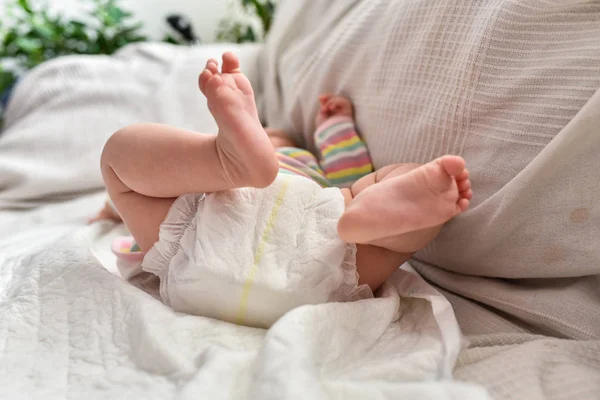 Newborn baby laying on a sofa with disposable diapers ready to c — Stock Photo, Image