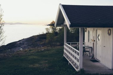 Norveç ahşap topuzun verandasında gece yarısı güneşinin tadını çıkarma