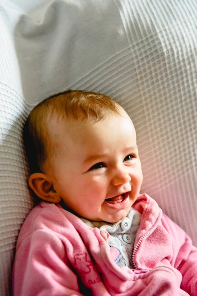 Adorable funny baby girl smiling with pink pajamas. — Stock Photo, Image