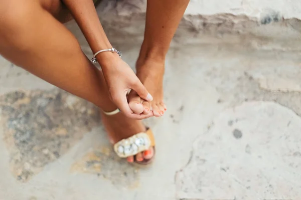 Turista mujer con los pies adoloridos y ampollas comprueba sus pies doloridos — Foto de Stock
