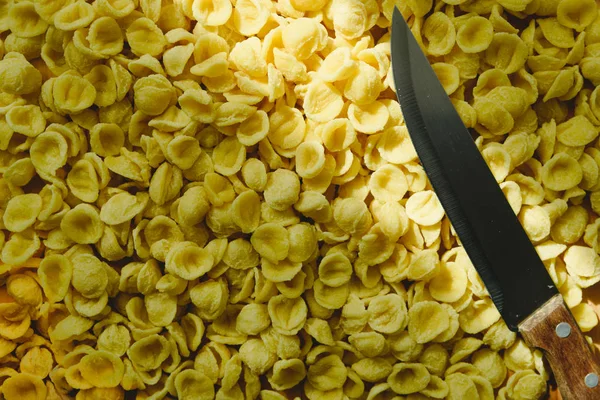 Orecchiette, Italiaanse tarwegries meel pasta, op een tafel en een knif — Stockfoto