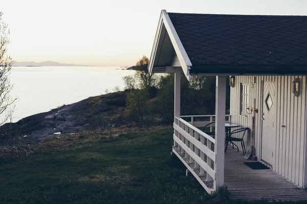 Norveç ahşap topuzun verandasında gece yarısı güneşinin tadını çıkarma