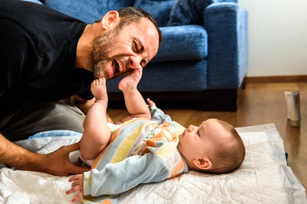 Papá luchando con su hija bebé para cambiar pañales sucios pu — Foto de Stock
