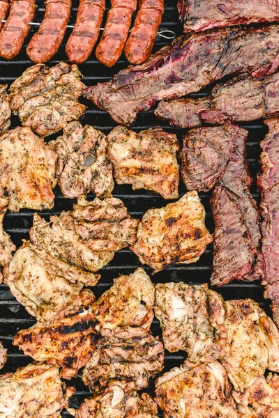 Salsicha, carne de porco e frango assados em um churrasco, visto de cima — Fotografia de Stock
