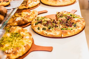 Bir sokak tezgahında birkaç küçük İtalyan tarzı pizza.