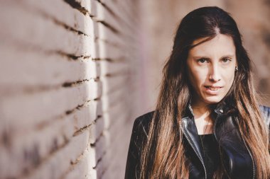 Deri ceket giyen uzun düz saçlı genç model kadın