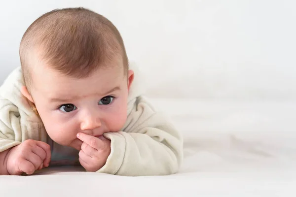 Portrait of an adorable smiling baby biting her own fingers putt — Stock Photo, Image