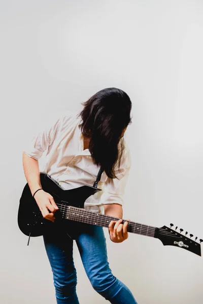 Jovem guitarrista de cabelos longos animado jogando seu preto elétrico g — Fotografia de Stock