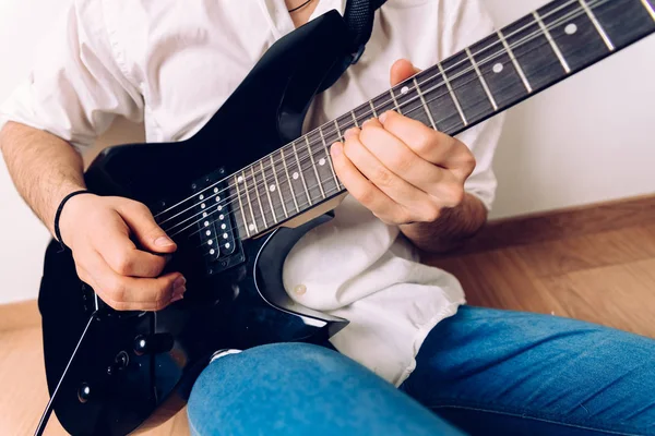 Close-up das mãos de um guitarrista tocando uma música enquanto pressiona as cordas . — Fotografia de Stock