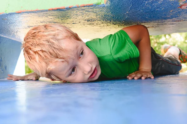 Niño jugando al escondite en un laberinto urbano de hormigón buscando —  Fotos de Stock
