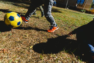 Summe'de bir dostluk maçında eski bir futbol toplarını kovalayan çocuklar