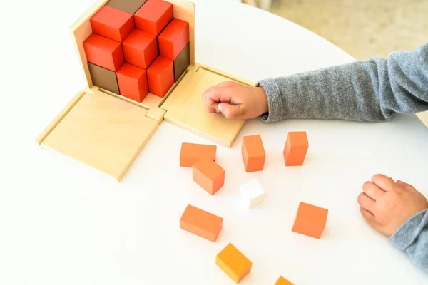 Las manos del niño aprenden a encajar piezas en un rompecabezas de madera 3d . — Foto de Stock