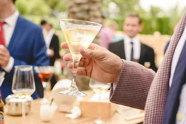 People in a cocktail drinking alcohol from their glasses and hav