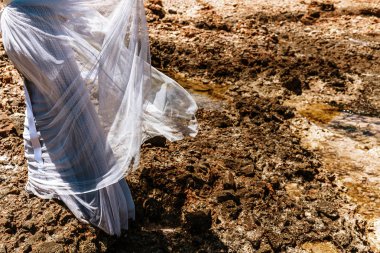 Tanınmayan bir kadın bir deniz kıyısında kayalar üzerinde yürüyüş giyen