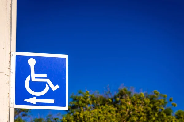 Blue square sign to indicate the way to disabled people in a whe
