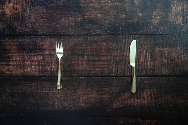 Antigua mesa de madera con tenedor y cuchillo esperando un plato de missi —  Fotos de Stock