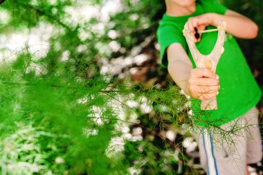 Okul arkadaşlarını sapanla tehdit eden çocuk.