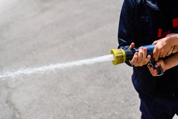消防员演示如何使用水管给儿童 — 图库照片