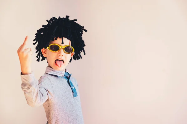 Kind mit lustiger Perücke zeigt Mittelfinger zum Lachen — Stockfoto