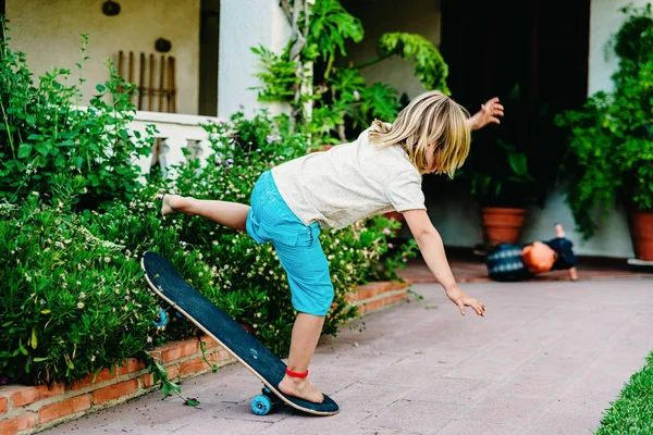5-jähriger Junge übt Schlittschuhlaufen in seinem Hinterhof, stolpert und — Stockfoto