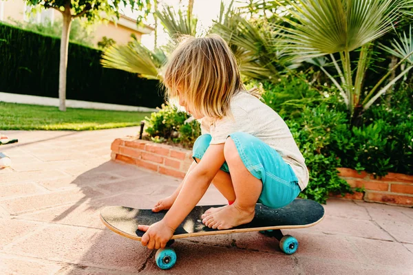 5 anos de idade menino praticando skate em seu quintal com medo de queda — Fotografia de Stock