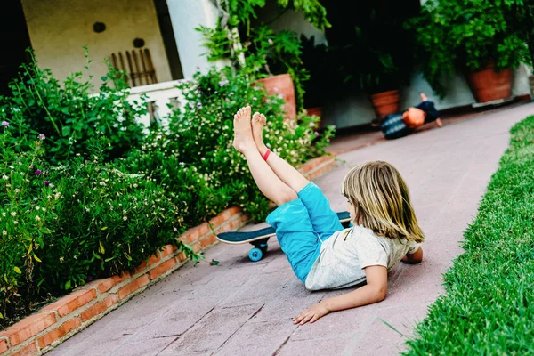 5 year old boy practicing skate in his backyard, stumbling and f — Stock Photo, Image