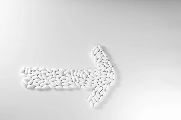 Flecha de dirección hecha con pastillas aisladas sobre fondo blanco, me — Foto de Stock