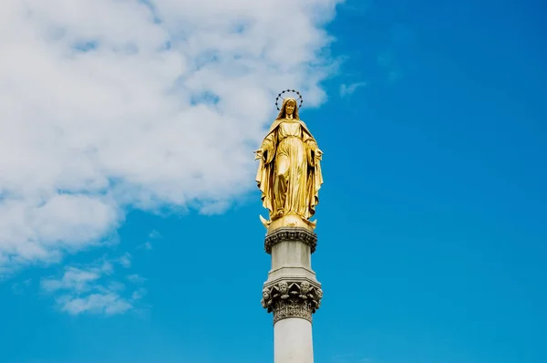 Gouden religieuze standbeeld, verlicht door de zon, van de Maagd M — Stockfoto