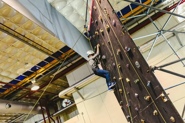 Jongen een klimwand klimmen naar de top te zijn angsten te overwinnen. — Stockfoto