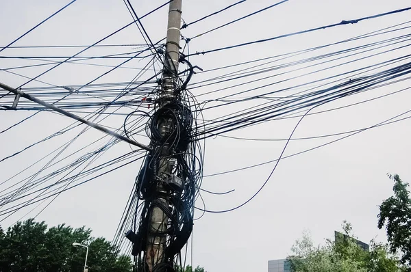 Деревянный столб, полный телефонных проводов, запутанных вместе, телеком — стоковое фото