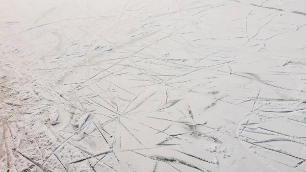 Fondo invernale di terreno ghiacciato con ghiaccio, con tracce di pattino — Foto Stock