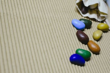 Arka plan ile dalgalı bir kağıt üzerinde dağınık renkli sahte taş