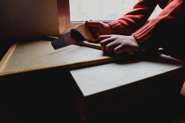 Çocuk bir süper kahraman olarak kılık değiştirmiş bir ahşap ile marangoz çalışması yapıyor 