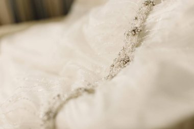 Beyaz bir gelinlik asılı detay.
