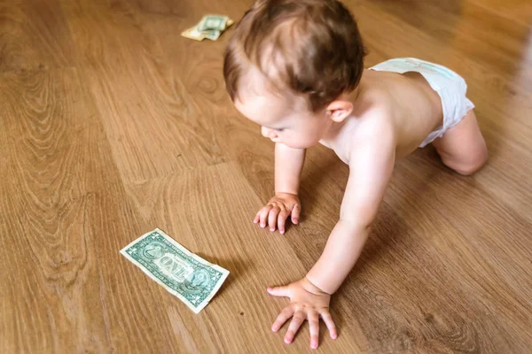 Bebê atingindo algumas notas de dólar, desperdiçado conceito de poupança familiar — Fotografia de Stock