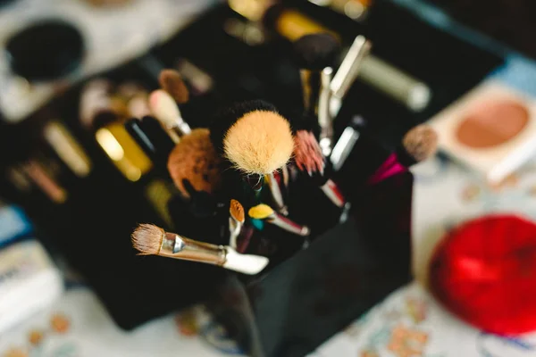 Borstar för makeup i en låda på en defokuserad tabell. — Stockfoto