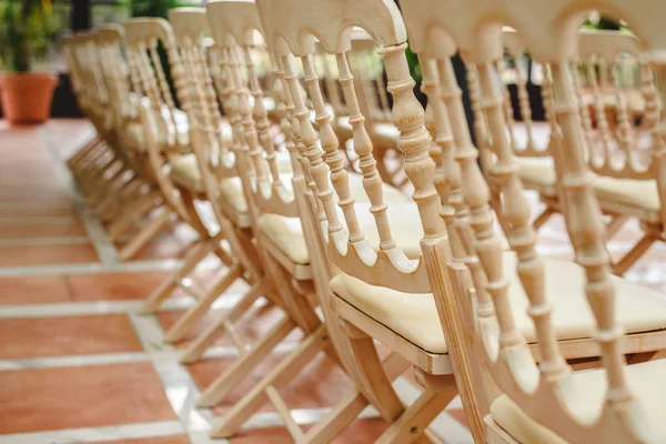 Mnoho prázdných bílých dřevěných židlí seřazených na retro-Style událost. — Stock fotografie